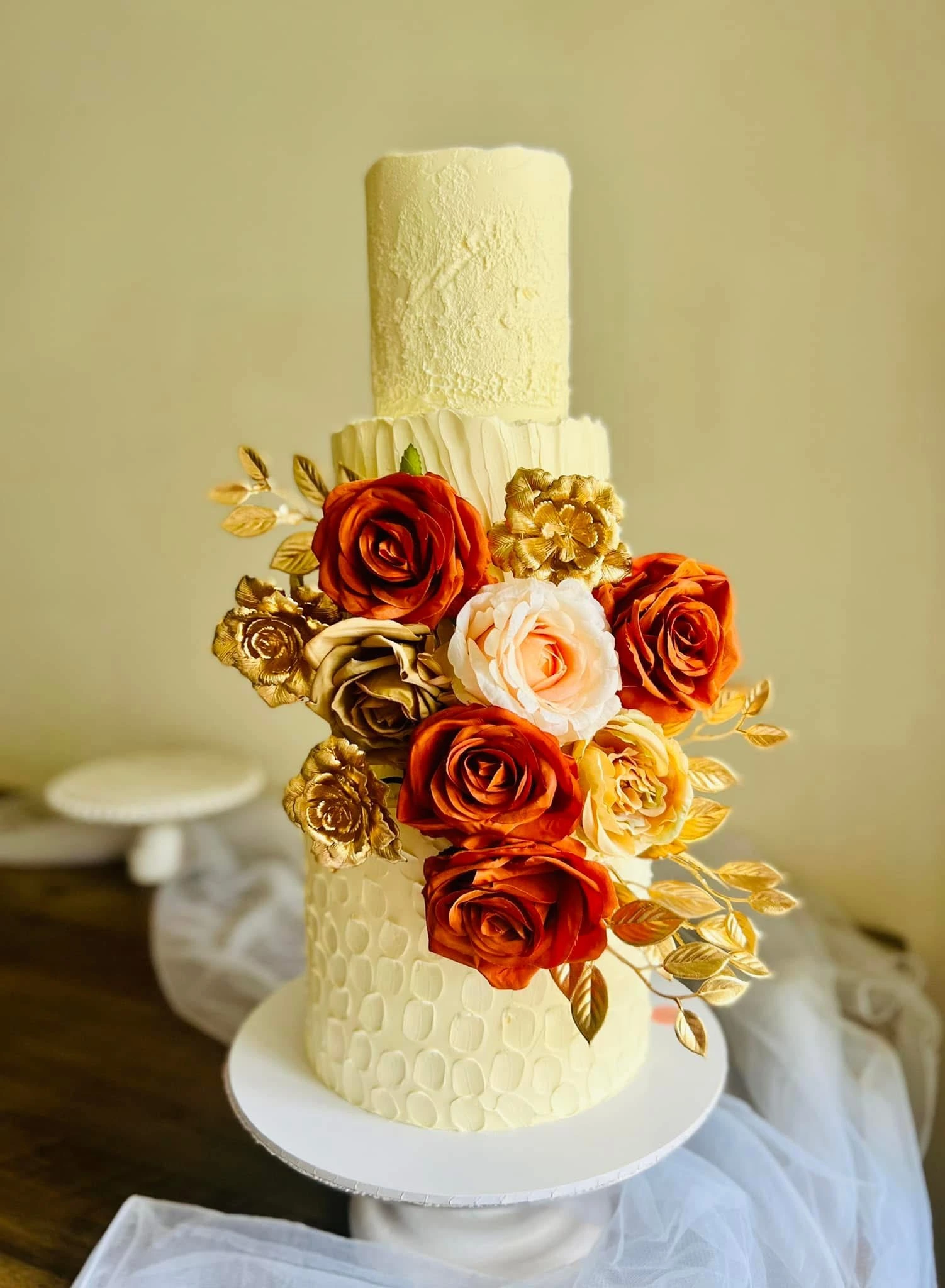 three tier wedding cake with different coloured flowers.